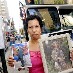 Gertrude Taylor holds photos of her brother Alvin Taylor, who is currently on tour of duty in Afghanistan and is facing losing his job as an MTA bus driver.  
