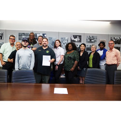 President Samuelsen, with the bikeshare negotiating committee, holds the new signed contract to smiles all around.