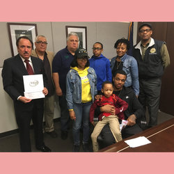 M3 Technology President John Pescitelli (at left) holds check for $89,250 which was presented to Michael Dicks (seated, with brother Jaelen, 4). Also present with the Dicks family were Union officers including Sec-Treas Earl Phillips and MOW VP Tony Utano