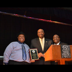 Stations VP Maurice Jenkins and Senior Director of Operations Curtis Tate give plaque to a representative of the 369 Harlem Hell Fighters Infantry Regiment
