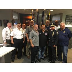Chief Edward Delatorre (front, wearing uniform hat) stands with TWU Local 100 President Tony Utano and Secretary-Treasurer Earl Phillips along with other personnel