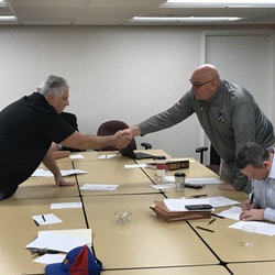 Local 100 President Tony Utano (left) and company Vice President Tony Murgo shake after settling the proposed 5-year contract.