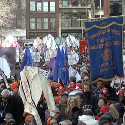 Local 100 banner at the centennial observance. Garments represent the 146 workers who perished in the blaze.